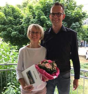 Maria Peters-Hunnekuhl hat die Weiterbildung für Pflegende in der Geriatrie erfolgreich absolviert und von Pflegefachleitung Christian Lemli ein Zertifikat und einen Blumenstrauß überreicht bekommen.